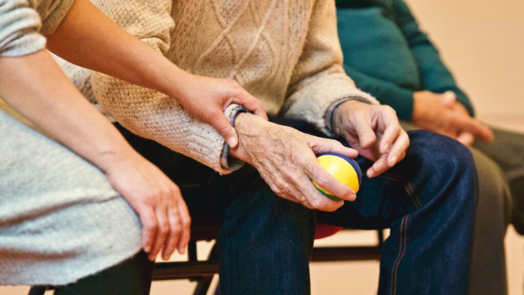 Elderly Man's hand being held by caregiver